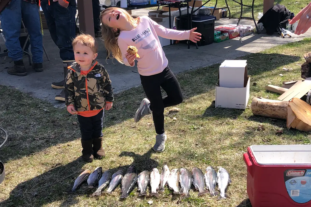 Two children showing off the fish they caught